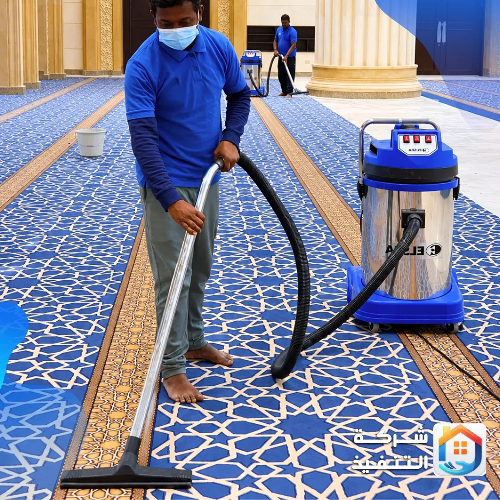 شركة تنظيف سجاد بالرياض: عامل ينظف سجاد مسجد بجهاز شفط احترافي وعامل آخر في الخلف