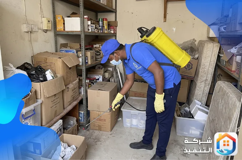 فني رش مبيدات بالرياض يرش أرضية مخزن صغير بين الكراتين ورفوف التخزين
