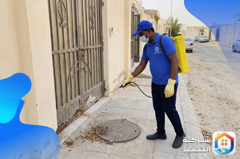 فني رش مبيدات يرش المحيط الخارجي لبيت في الرياض عند الباب وغطاء فتحة الصرف